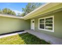 Close-up of a white front door with a window and a walkway leading to a well-maintained lawn at 1708 Nw 27Th Ave, Ocala, FL 34475