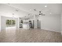 Open-concept living area with modern wood-look tile flooring and stainless steel appliances at 1708 Nw 27Th Ave, Ocala, FL 34475