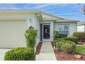 Inviting front entrance featuring a decorative storm door, manicured bushes, and a clear address marker at 1768 Sw 156Th Ln, Ocala, FL 34473