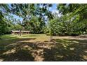 Picturesque view of a home surrounded by mature trees and a sprawling lawn under a blue sky at 19130 Nw 60Th Ave, Reddick, FL 32686