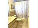 Cozy bathroom featuring tiled floors, shower with tub, and decorative floral accents at 2305 Ne 40Th Ave, Ocala, FL 34470