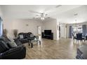 Spacious living room with wood-look tile flooring and a comfortable leather sofa set at 28 Hemlock Radial Loop, Ocala, FL 34472
