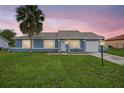 Lovely exterior view of home showing freshly cut lawn, blue paint, and a charming palm tree at 316 Oak Track Dr, Ocala, FL 34472