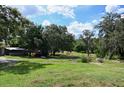 Lush backyard with mature trees and ample green space, perfect for outdoor activities at 4501 Detour Rd, Haines City, FL 33844