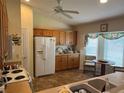 Bright kitchen with ample cabinet space, white refrigerator, ceiling fan, and a cozy breakfast nook at 4622 Ne 15Th St, Ocala, FL 34470