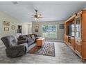 Inviting living room with wood-look tile floors, a ceiling fan, and a large window at 4660 Se 142Nd Ln, Summerfield, FL 34491