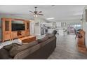 Open-concept living room with wood-look floors connecting to a bright kitchen with white cabinets at 4660 Se 142Nd Ln, Summerfield, FL 34491