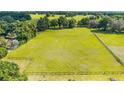 Beautiful lot showcasing a vast field enclosed by a rustic wooden fence and mature trees at 475 Ne 155Th Pl, Citra, FL 32113