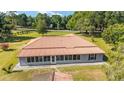 Rear aerial view of a home boasting a red tile roof, sunroom and expansive greenery at 475 Ne 155Th Pl, Citra, FL 32113