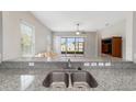 Kitchen bar top overlooks the living room, complemented by granite counters and stainless steel sink at 6299 Sw 90Th St, Ocala, FL 34476