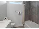 This modern bathroom features a tub with dark grey tiling and white tiling, a towel rack, and an open window at 6760 Sw 128Th Loop, Ocala, FL 34473