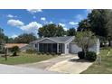 Charming single-story home featuring a screened-in porch, well-manicured lawn, and attached garage at 8650 Sw 108Th Pl, Ocala, FL 34481