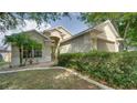 Inviting home exterior features a well-kept lawn, lush shrubbery, and an arched entry at 949 Woodsong Way, Clermont, FL 34714