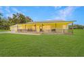 Charming yellow ranch home with a metal roof, a covered porch and an oversized two-car garage at 975 Cr 542E, Bushnell, FL 33513