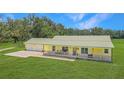 Charming yellow ranch home with a metal roof and a covered porch on a large lot at 975 Cr 542E, Bushnell, FL 33513