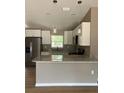 Modern kitchen with stainless steel appliances, granite counters, and bright overhead lighting at 10375 Se 126Th Ln, Belleview, FL 34420
