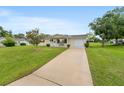 Inviting home showcasing a charming porch and attached garage, set on a well-maintained lot at 10720 Sw 63Rd Ave, Ocala, FL 34476