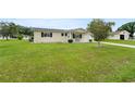 A well-manicured lawn complements this lovely single-story home with black shutters at 10720 Sw 63Rd Ave, Ocala, FL 34476