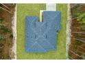 High angle view of a well manicured yard, gray roof, and surrounding wooded area at 13145 Sw 78Th Cir, Ocala, FL 34473