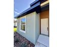 Exterior corner view showcasing light green siding, black trim, and a white front door at 13239 Sw 60Th Avenue Rd, Ocala, FL 34473