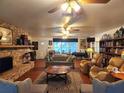 Cozy living room featuring a stone fireplace, hardwood floors, and built-in bookshelves at 17051 Ne 243Rd Place Rd, Fort Mc Coy, FL 32134