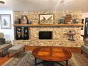 Bright living room showcasing a stunning stone fireplace and mantle with decorative accents at 17051 Ne 243Rd Place Rd, Fort Mc Coy, FL 32134