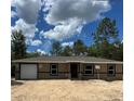 Charming single-story home features a neutral exterior, a single-car garage, and a clear view of the blue, sunny sky at 21712 Sw Rainbow Lakes Blvd, Dunnellon, FL 34431