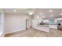 Bright, open-concept living area with vaulted ceilings, wood-look flooring, and seamless flow into a modern kitchen at 2264 Sw Moines Ct, Dunnellon, FL 34431