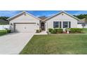 Charming single-Gathering home with an inviting front yard and well-maintained landscaping under a clear blue sky at 2552 Ne 42Nd Rd, Ocala, FL 34470