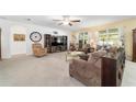 Spacious carpeted living room with large windows and comfortable seating, perfect for relaxation and entertainment at 2552 Ne 42Nd Rd, Ocala, FL 34470