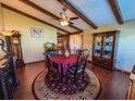 A dining room with wood floors, wood beams, a ceiling fan, and a round rug under the table at 3545 Se 24Th Ave, Ocala, FL 34471