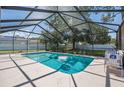 Screened-in pool area with clear blue water, lounge chair, and a view of the backyard at 4300 Nw 4Th Cir, Ocala, FL 34475