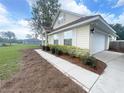 Well-maintained home with a two-car garage, a sidewalk, and professional landscaping at 5917 Ne 61St Avenue Rd, Silver Springs, FL 34488
