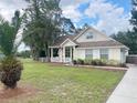 Inviting single-Gathering home with a welcoming front porch, lush lawn, and mature trees at 5917 Ne 61St Avenue Rd, Silver Springs, FL 34488