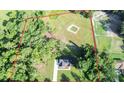 Expansive property featuring a modern home, green fields, mature trees, a small pond, and fenced perimeter at 7 Hill Prince Dr, Ocala, FL 34482