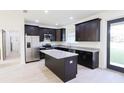 Modern kitchen featuring dark wood cabinets, granite countertops, stainless steel appliances, and center island at 7 Hill Prince Dr, Ocala, FL 34482
