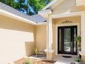 Inviting front entrance featuring a decorative door, stone accents, and charming landscaping at 7695 Sw 188Th Ave, Dunnellon, FL 34432