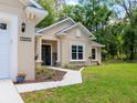Close-up of a front entrance with beautiful landscaping, a decorative door, and manicured lawn at 7695 Sw 188Th Ave, Dunnellon, FL 34432