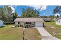 Inviting single-story home featuring a well-manicured lawn, charming porch, and attached garage at 8144 Sw 108Th Street Rd, Ocala, FL 34481
