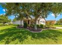 Attractive home with manicured landscaping and a paver driveway, shaded by a large, mature tree at 8566 Sw 83Rd Loop, Ocala, FL 34481
