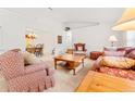 Cozy living room with patterned sofas, wooden coffee table, and view to dining area at 10151 Sw 41St Ter, Ocala, FL 34476