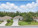 An aerial view showcases a beautiful home with lush landscaping and a sprawling green lawn at 11728 Se 91St Cir, Summerfield, FL 34491