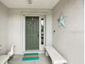 A welcoming front porch features a decorative door, bench and a whimsical goose statue at 11728 Se 91St Cir, Summerfield, FL 34491
