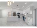 Modern kitchen with white cabinetry, quartz countertops, stainless steel appliances, and a large island at 13741 Sw 81St Cir, Ocala, FL 34473