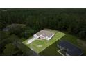 An aerial shot of a well-maintained home with a spacious yard surrounded by lush trees, showcasing the property's privacy at 144 Malauka Pass, Ocklawaha, FL 32179