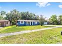 Well-maintained blue single-story home with a large front yard and mature palm trees at 14761 Sw 35Th Terrace Rd, Ocala, FL 34473