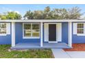 Close-up of a home's front porch featuring a modern black door and freshly painted porch at 14761 Sw 35Th Terrace Rd, Ocala, FL 34473