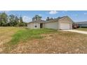 View of the home's exterior showcasing the attached garage and the front yard at 15711 Sw 52Nd Avenue Rd, Ocala, FL 34473