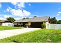 Beautiful single-story home with a lush green lawn, long driveway, and attached two-car garage at 2201 Ne 45Th St, Ocala, FL 34479