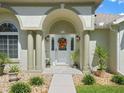 Inviting front entrance featuring a decorative door with sidelights, columns, and colorful landscaping at 2478 Nw 53Rd Avenue Rd, Ocala, FL 34482